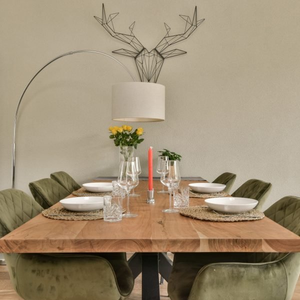a dining room with chairs and a table set for four, in front of a large white cabinetd refrigerator